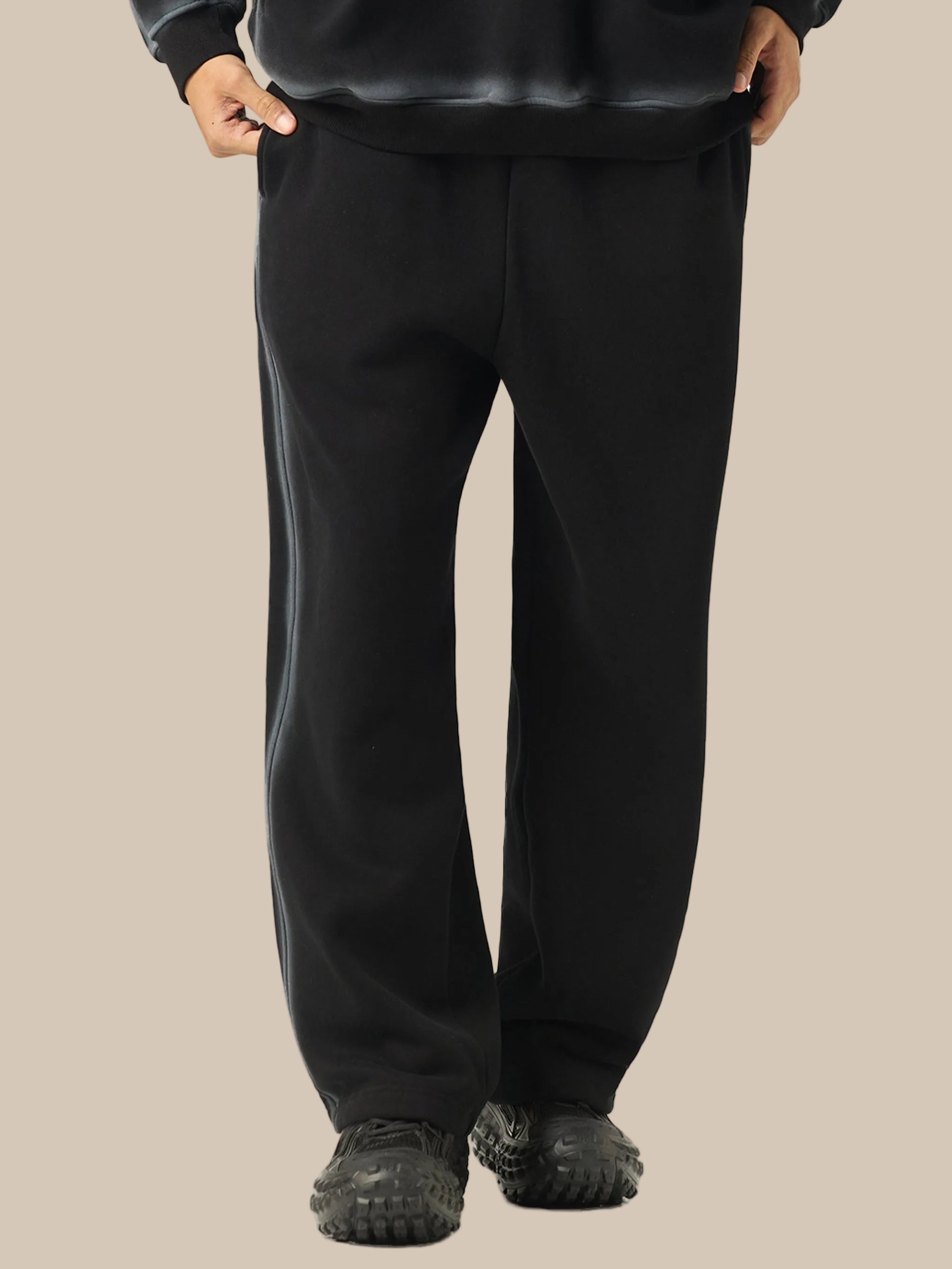 Black pants worn by a person on a white background