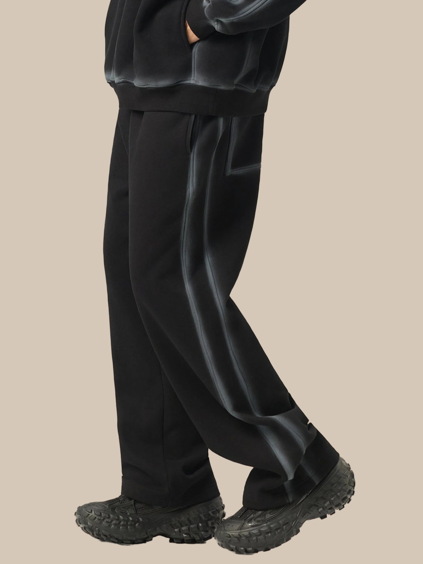 Person wearing black pants and shoes on a white background