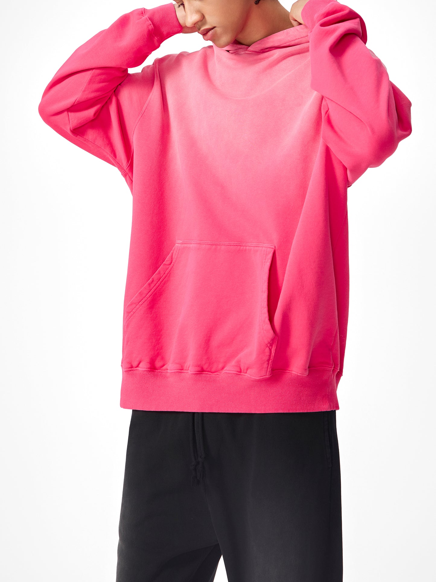 Model wearing a sustainable Future-Homme Ombre Hoodie with kangaroo pockets in pink frontside on a white background. 