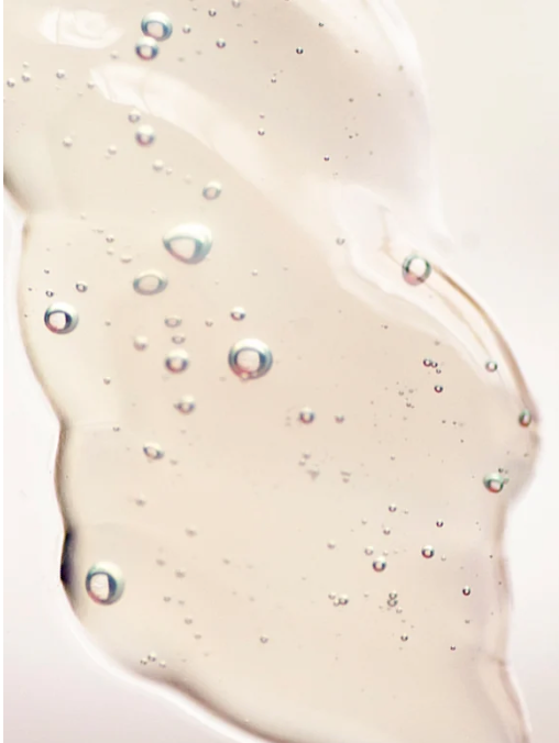 Close-up of a beige-colored liquid with bubbles on a white background