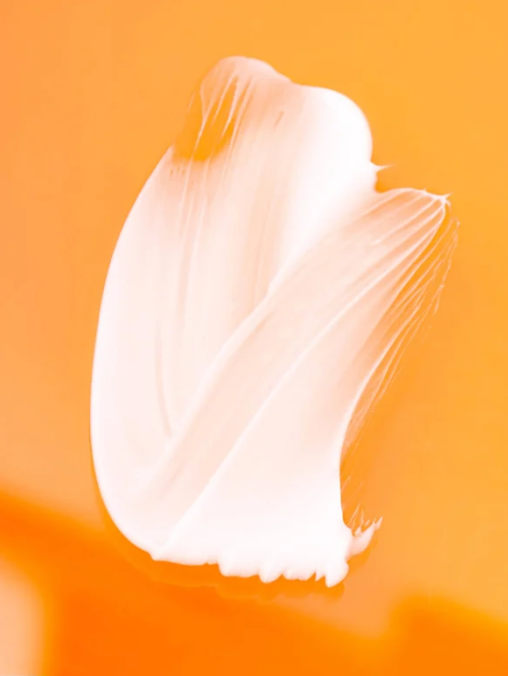 Eye cream smear on an orange background.  