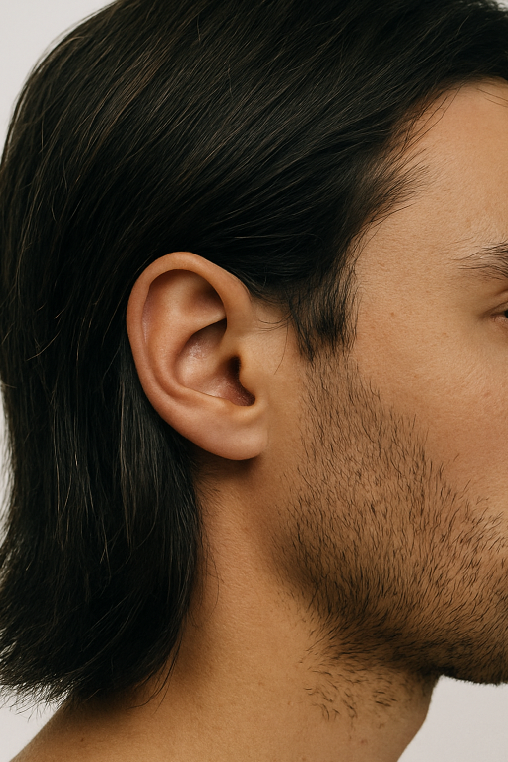 Side profile of a male hair style. Black hair length to neck behind ear. 