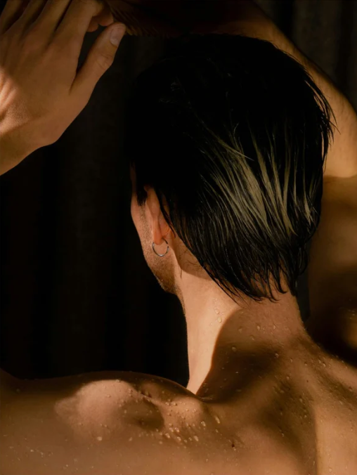 Close-up of a person with wet hair and skin, possibly after a shower or bath.