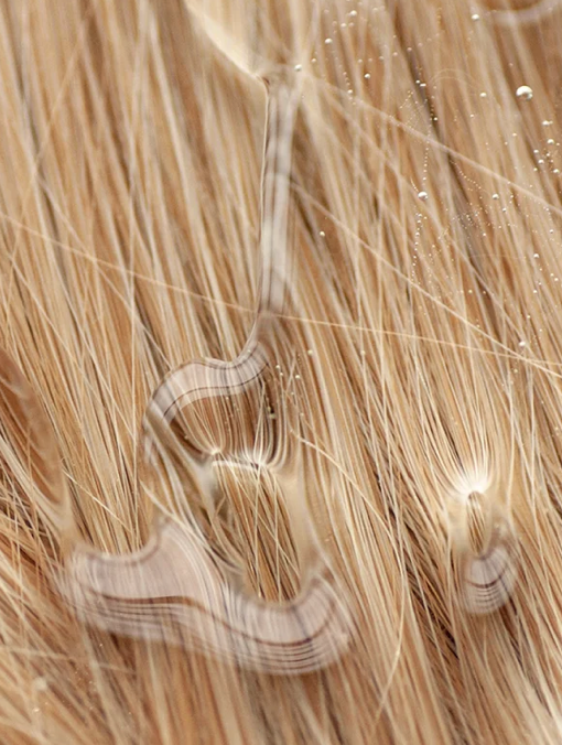 Close-up of blonde hair extensions with a focus on texture and color.