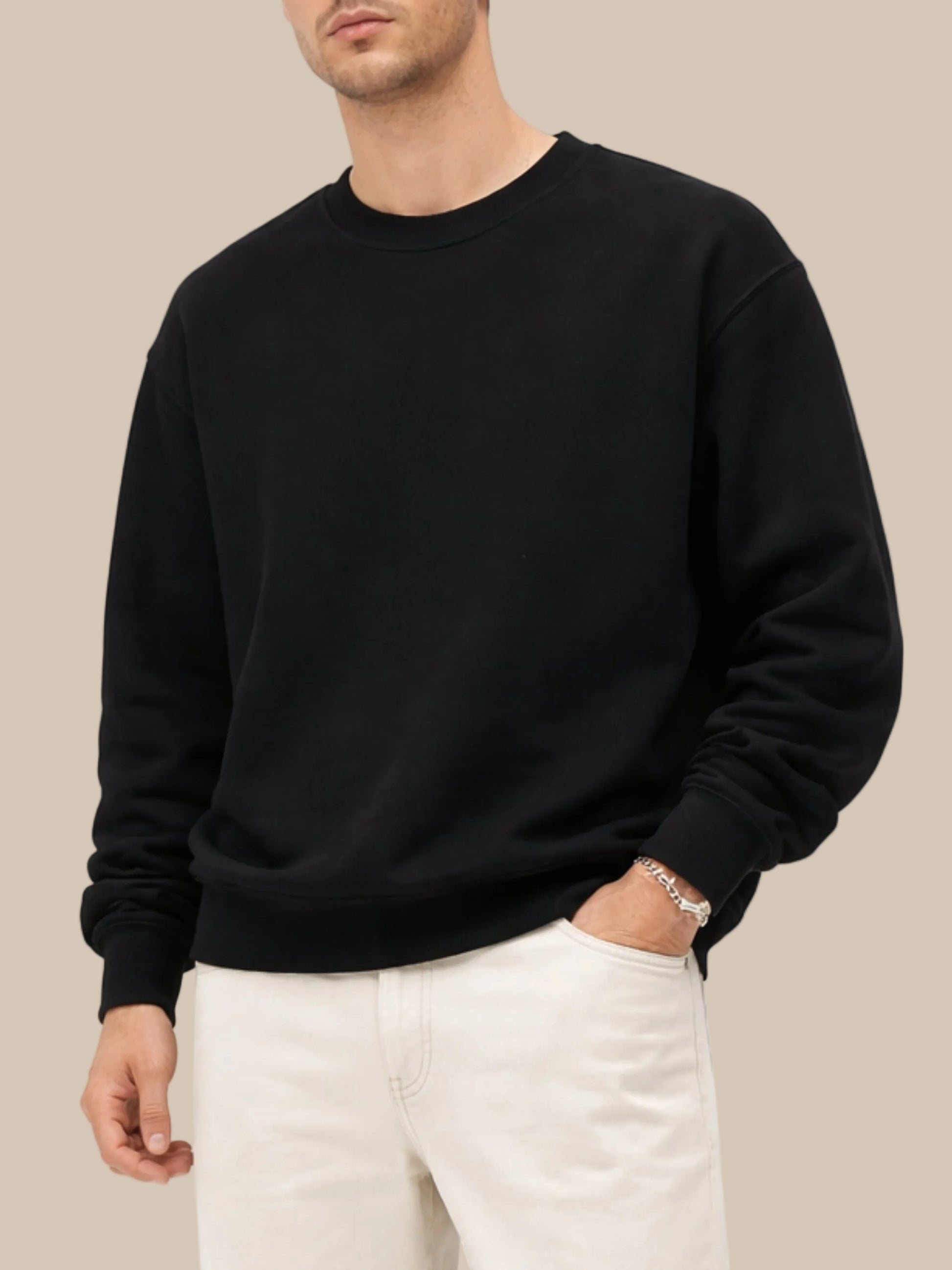 a person wearing a black cotton pullover sweatshirt with beige jeans on a white background 