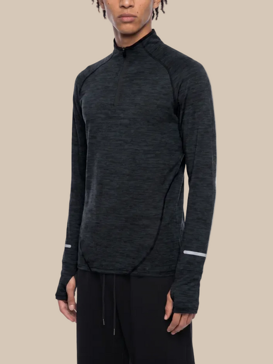 A person wearing a long sleeve technical training top in heathered gray on a white background. 