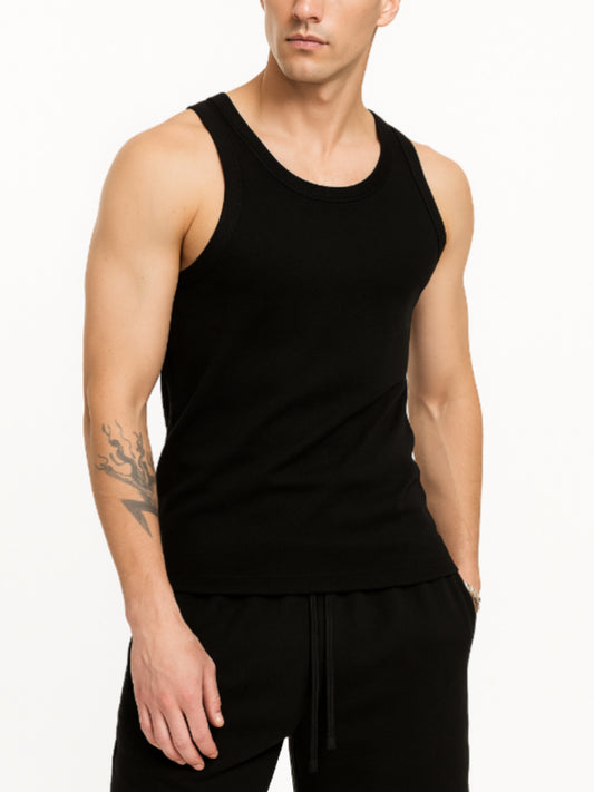 Man wearing a black tank top and black pants on a white background