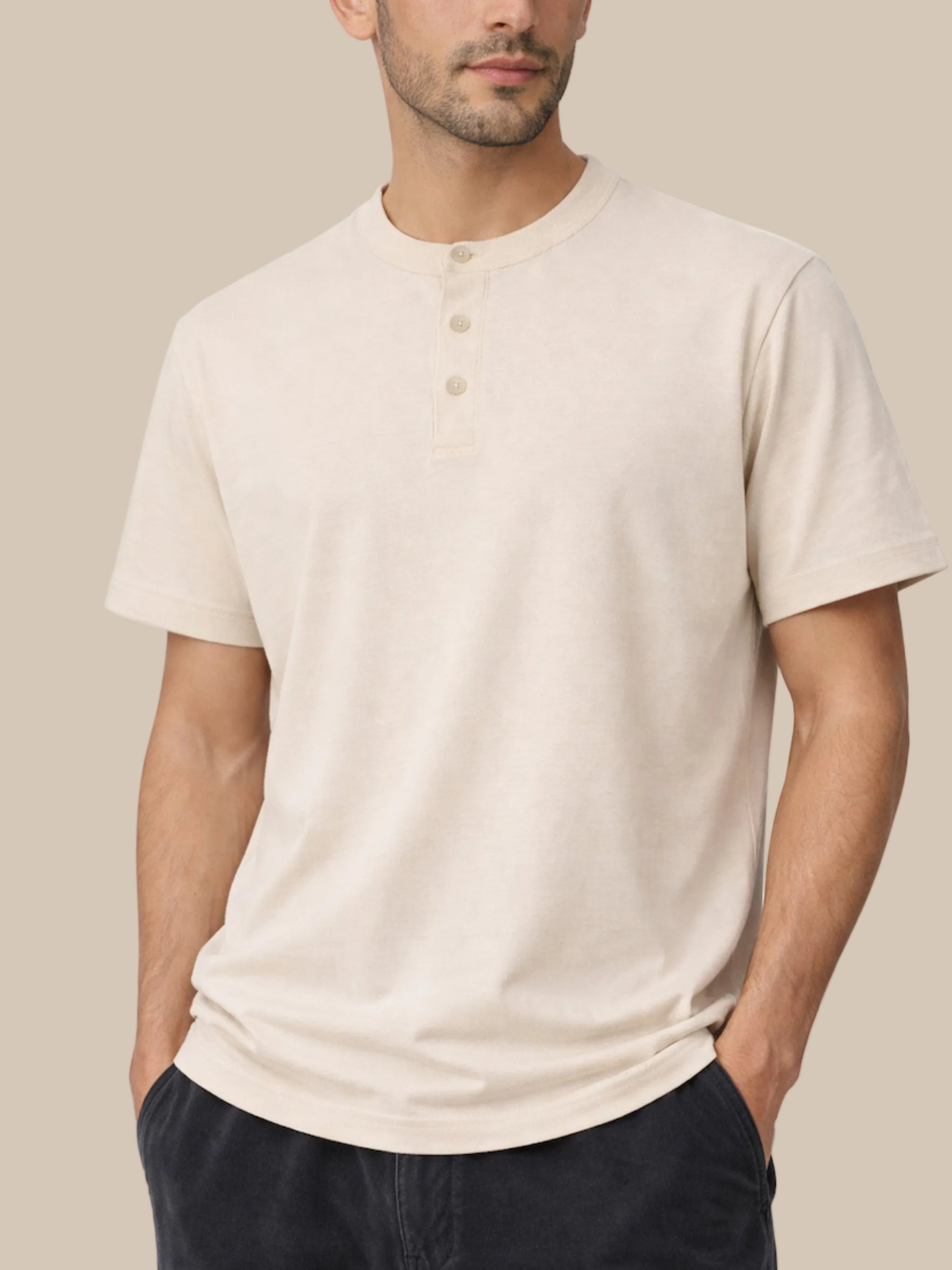 Man wearing a beige henley shirt against a white background