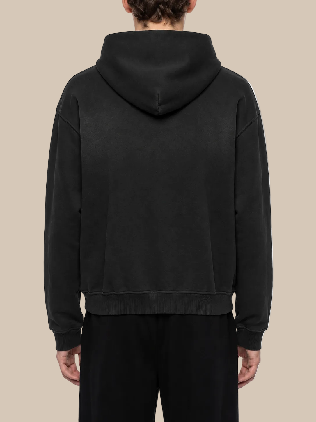 Person wearing a black hoodie from behind on a white background