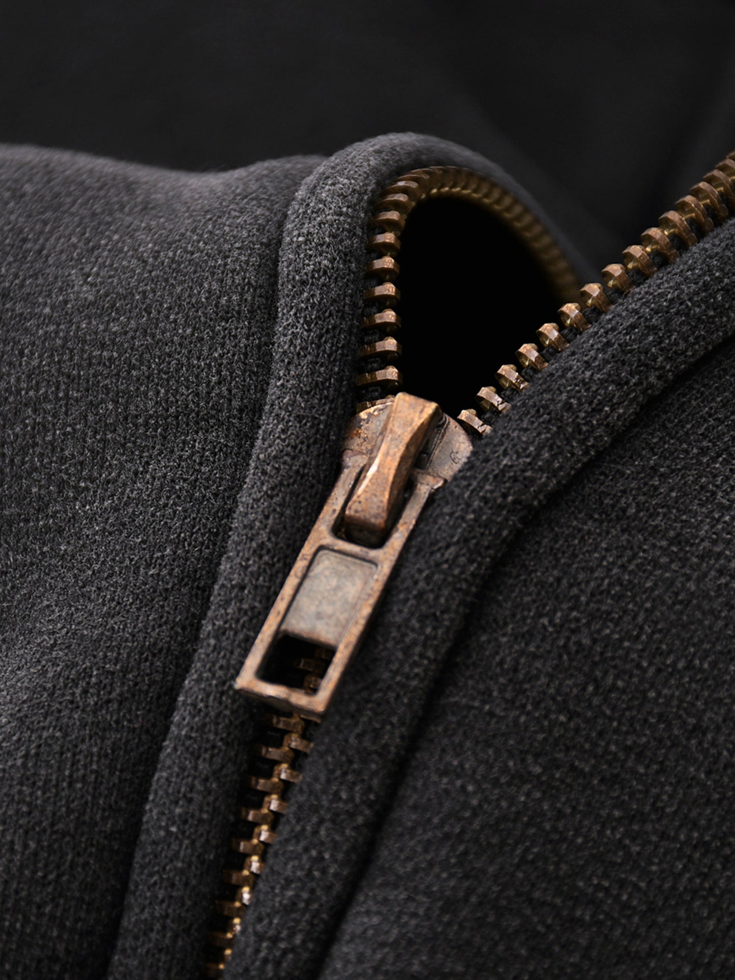 Close-up of a zipper on a dark fabric background