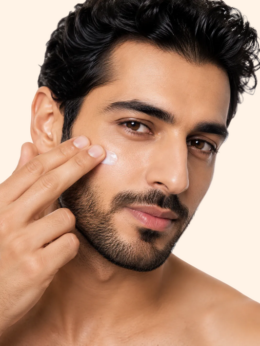 Man applying cream to his face against a white background