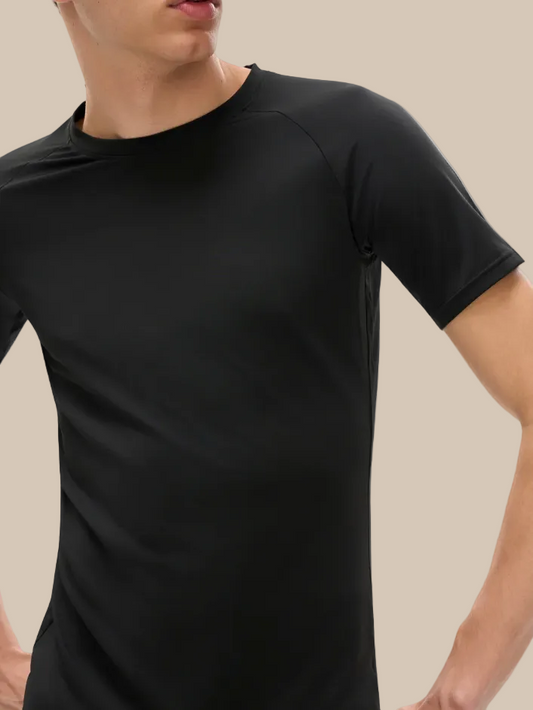 Person wearing a black technical performance t-shirt on a white background
