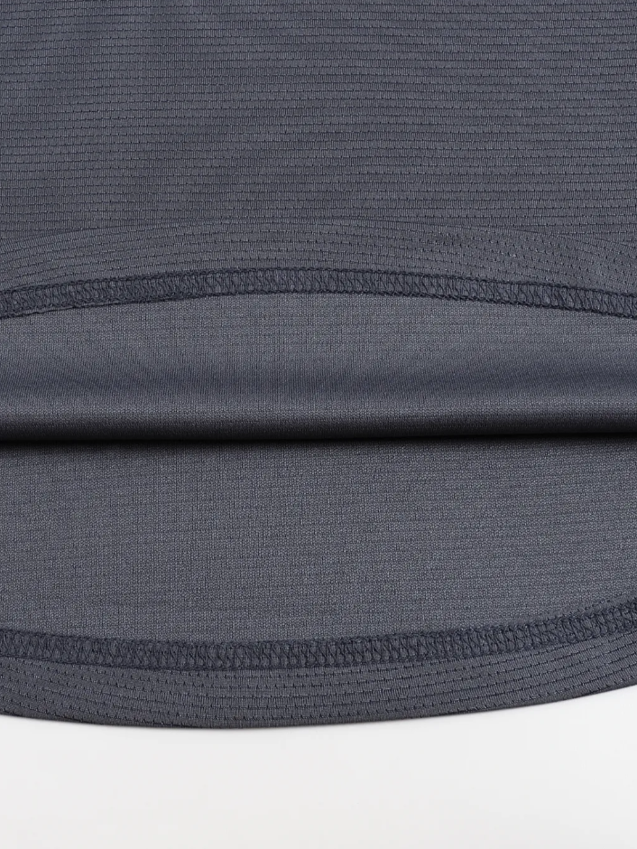 Close-up of a gray athletic shirt with mesh panels on a white background