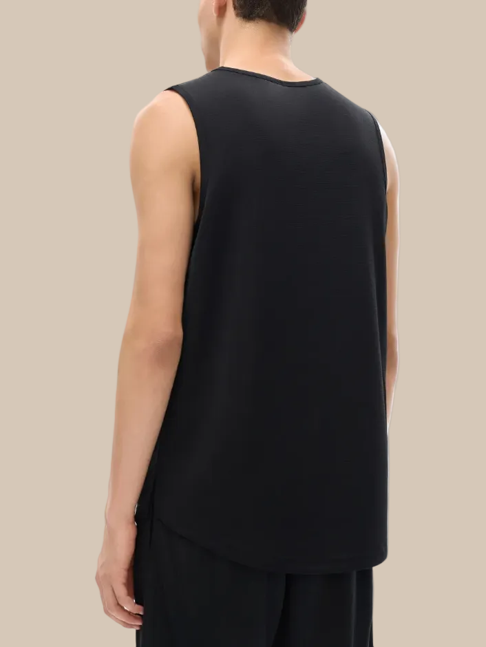 Person wearing a black sleeveless top on a white background