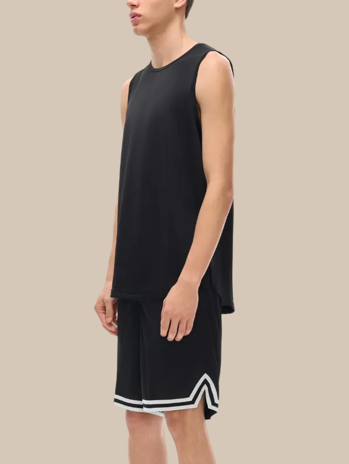 Person wearing a black sleeveless shirt and shorts with white trim on a white background