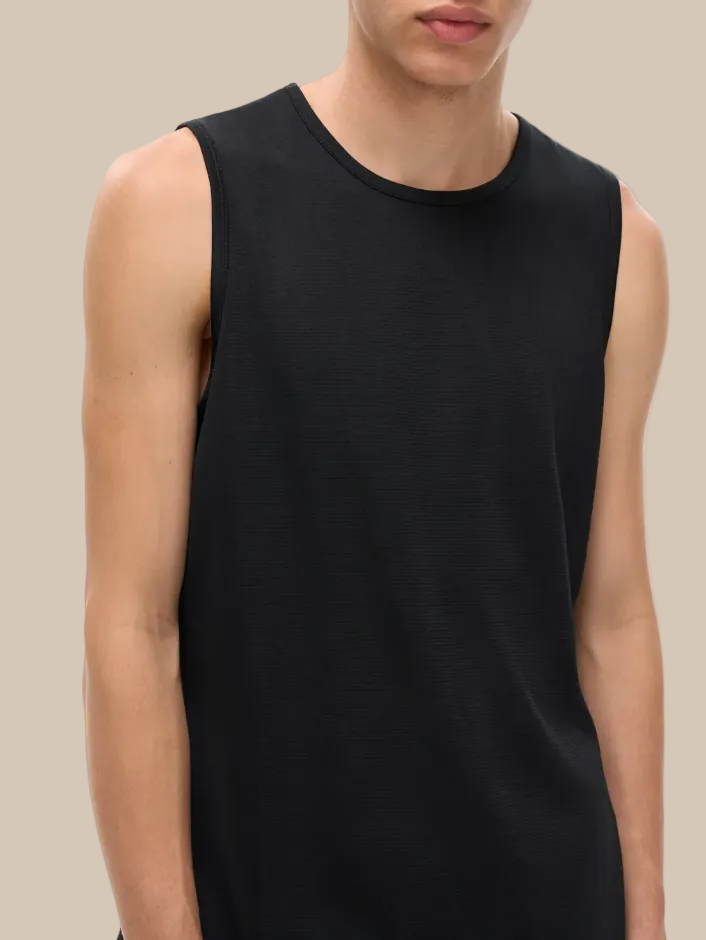Person wearing a black sleeveless shirt on a white background