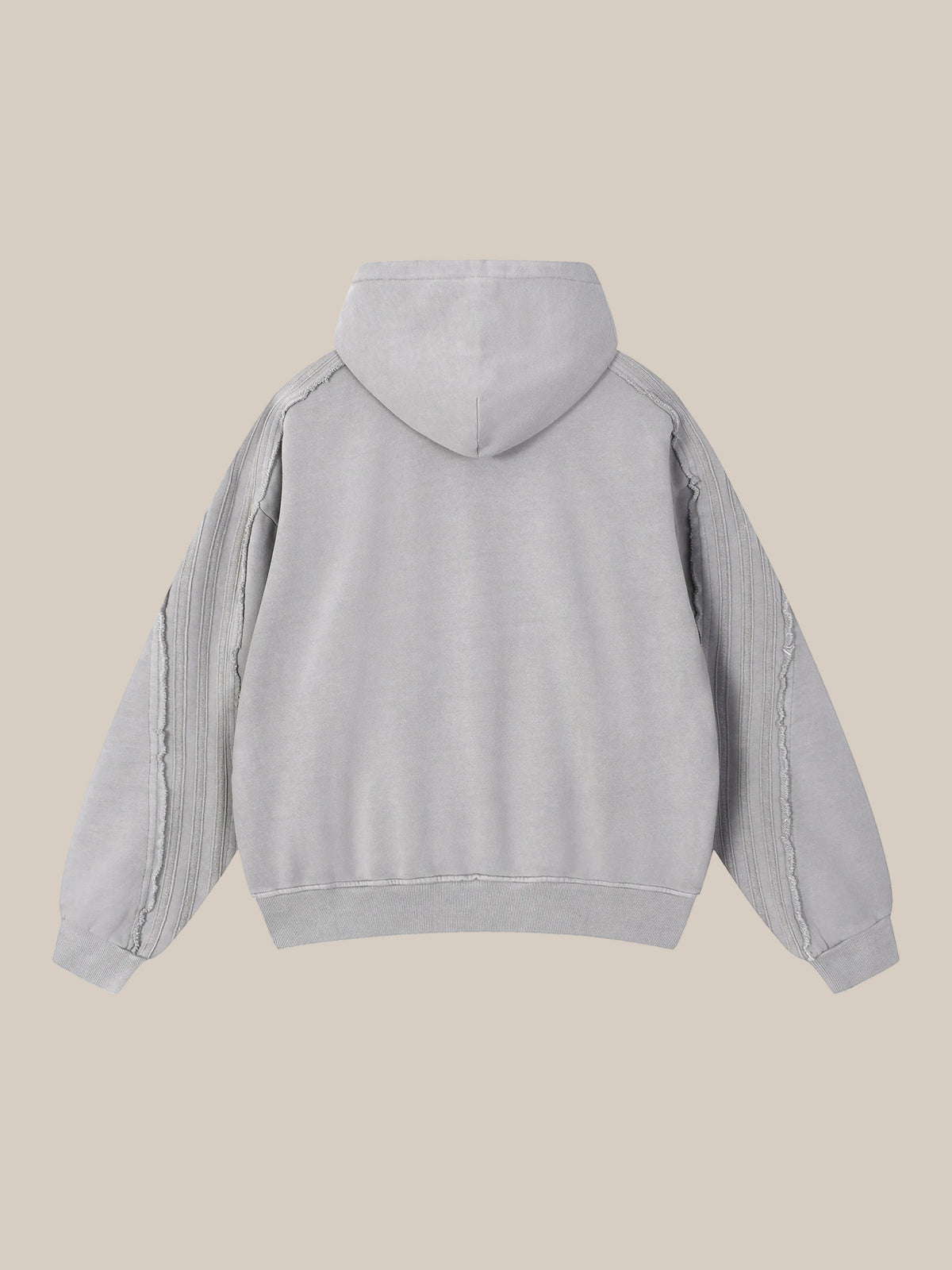 Backside of a sun bleached deconstructed light gray hoodie on a beige background.