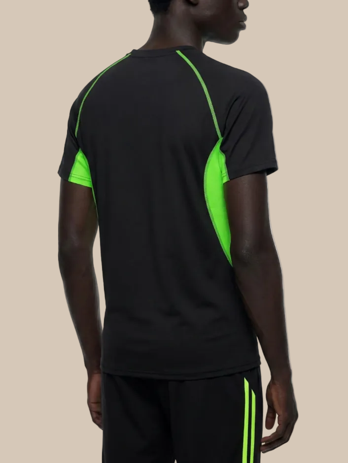 A man wearing a contrast panel training t-shirt in black and neon green on a beige background. 