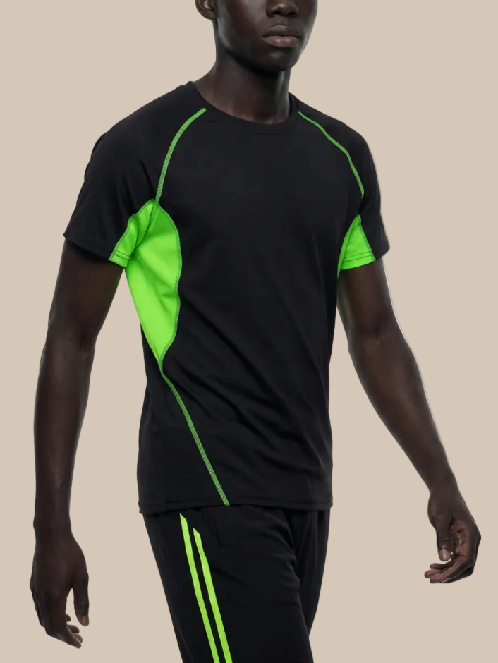 A man wearing a contrast panel training t-shirt in black and neon green on a beige background. 