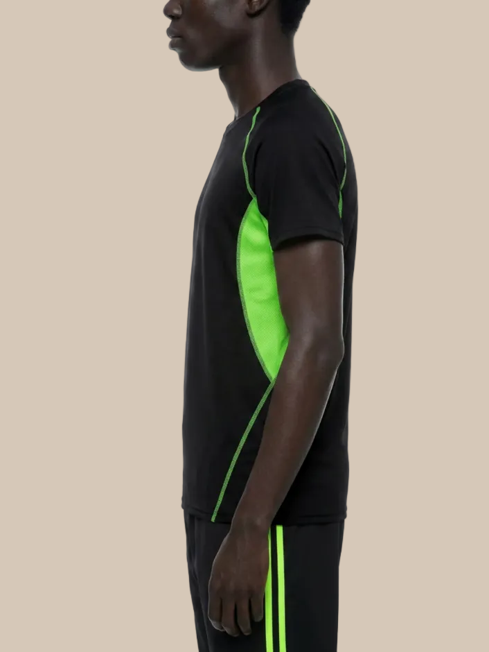 A man wearing a contrast panel training t-shirt in black and neon green on a beige background. 