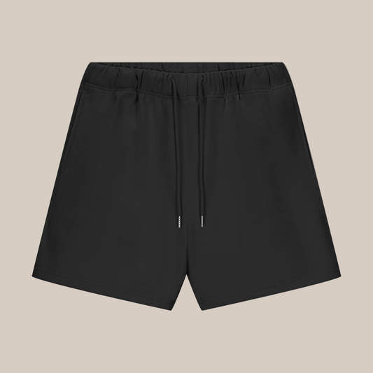 Black shorts with drawstring on a beige background
