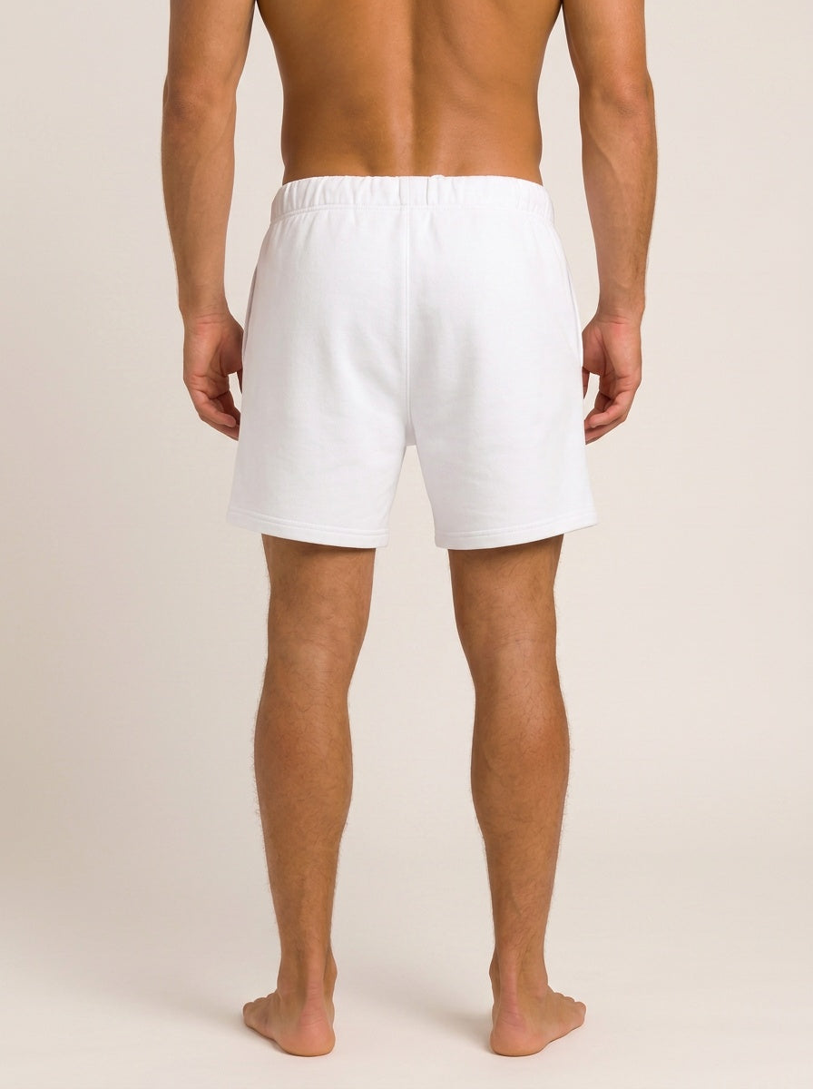 White men's shorts shown from the back on a model, photographed against a plain light beige studio background.