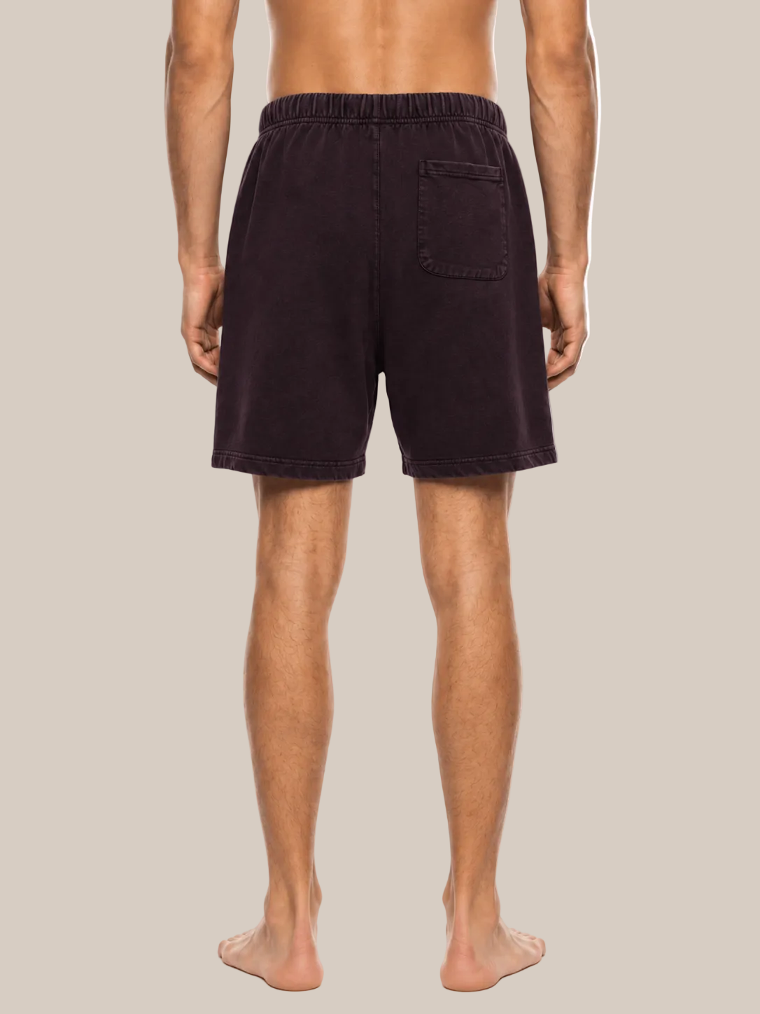 Rear view of a man wearing dark plum-colored lounge shorts against a plain white background.