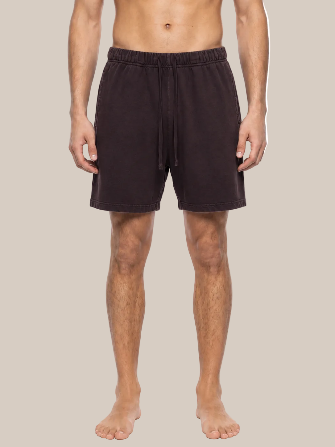 A man wearing dark brown drawstring lounge shorts, shown from the waist down against a plain white background.