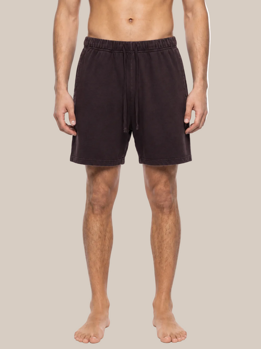 A man wearing dark brown drawstring lounge shorts, shown from the waist down against a plain white background.