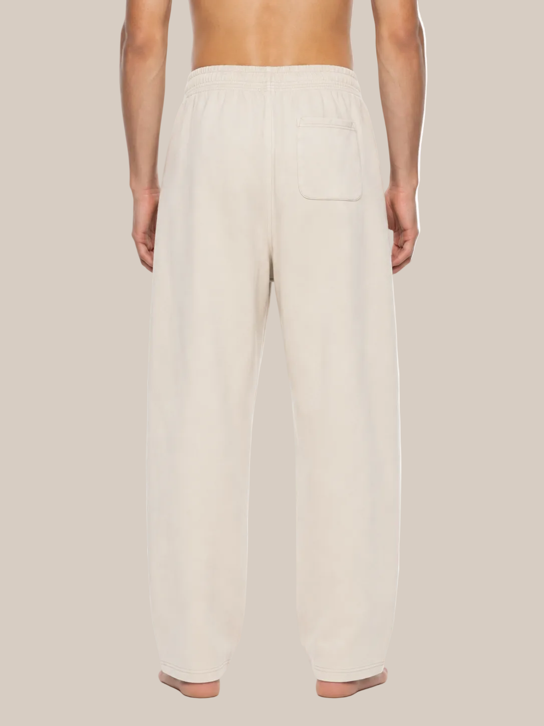 A man shown from the back wearing cream-colored lounge pants with a single back patch pocket, photographed against a plain white background.