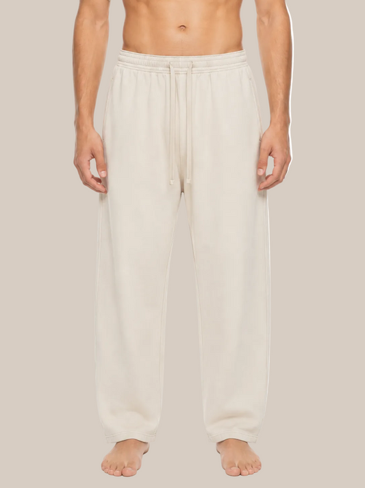A man wearing light beige drawstring sweatpants, shown from the waist down against a plain white background.